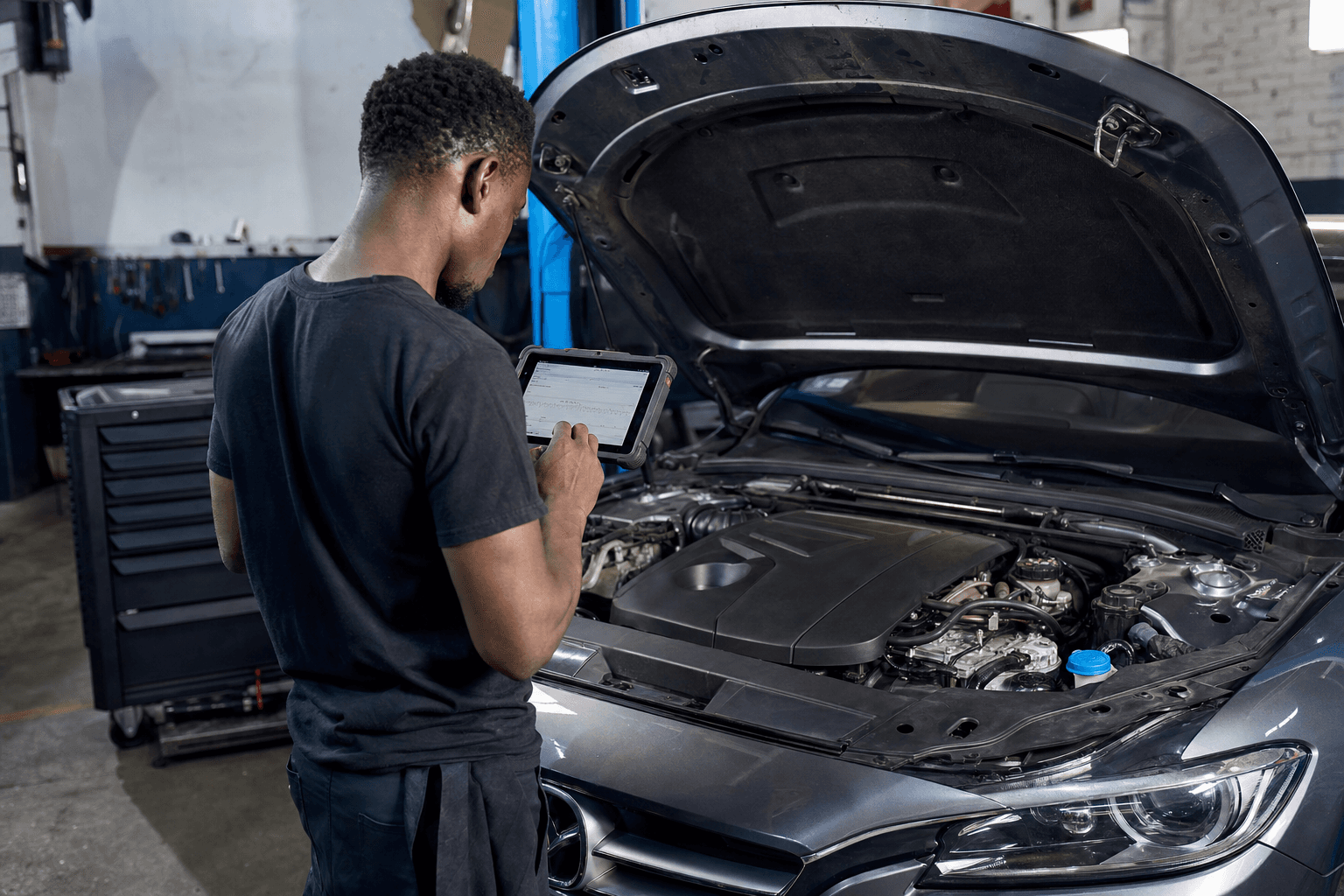 Technician inspecting a vehicle engine